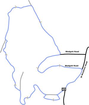 Map depicting a winding trail route, marked in blue, intersecting with Blodgett Road. The trail features several curves and loops, with additional roads labeled, including W Mountain Road and TH. The layout illustrates the path's configuration within the surrounding area. Blodgett mountain bike trail.