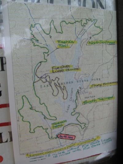 Map of the hiking trails in a state park, featuring labeled paths such as Tanka Trail and Northland Head, with a marked "You Are Here" location. The map includes contour lines and an overview of the surrounding area. Lake Lurleen State Park Trail mountain bike trail.