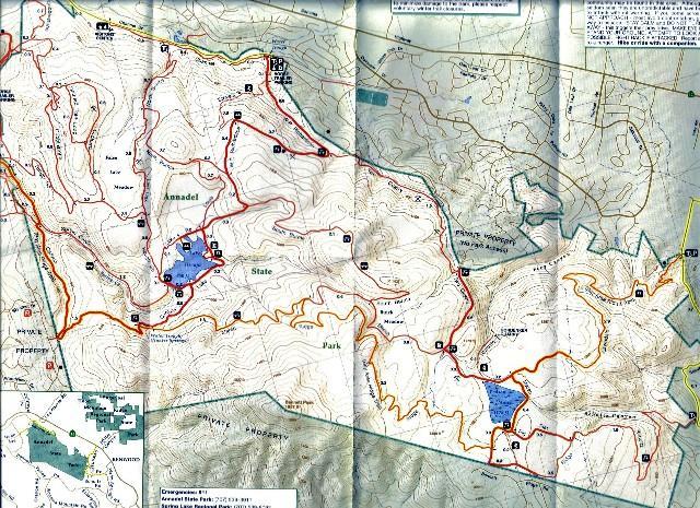A detailed topographic map showing trails, bodies of water, and geographic features in a park area. The map includes marked paths, elevation lines, and a smaller inset map for orientation. Annadel State Park mountain bike trail.