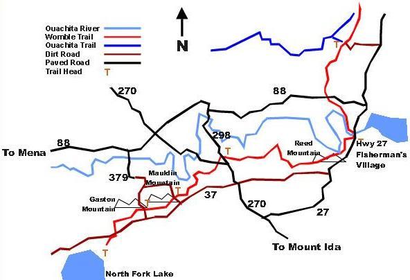 Map of the Ouachita River area, featuring trail routes and roadways. The map includes the Ouachita Trail and Womble Trail in blue, various dirt and paved roads in black and red, and marks locations such as Mount Ida, Mena, and Fisherman’s Village. Directions are indicated, with a north arrow at the top. Womble mountain bike trail.