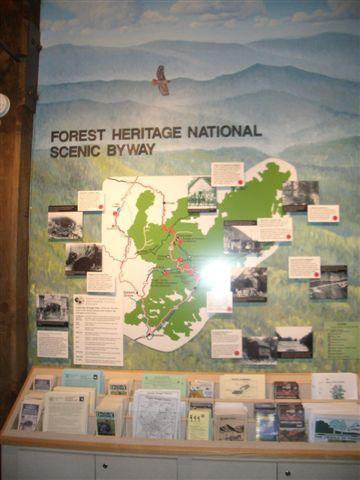 Map and informational display for the Forest Heritage National Scenic Byway, featuring a detailed map, photographs, and text highlighting points of interest and historical facts. Black Mountain mountain bike trail.