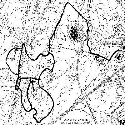 A topographic map featuring contour lines and marked trails. The areas are outlined in black, showing the terrain and elevation changes in a specific outdoor region. The map includes landmarks and labels, illustrating geographical features and trails. Ft. Drum Trail mountain bike trail.