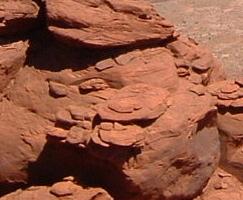 A close-up view of layered red rock formations, showcasing natural erosion patterns and textures. Hurrah Pass mountain bike trail.