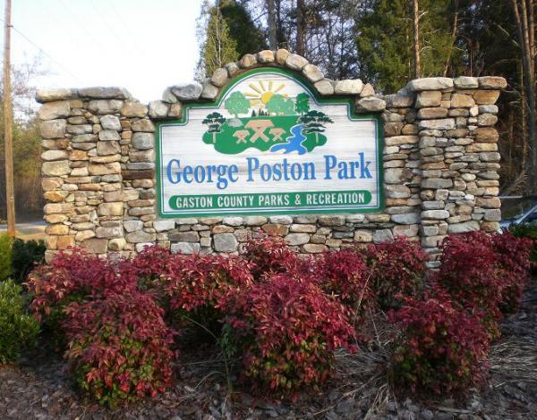 Sign for George Poston Park, featuring stone structure and colorful landscaping, with the text "George Poston Park" and "Gaston County Parks & Recreation." George Poston Park mountain bike trail.
