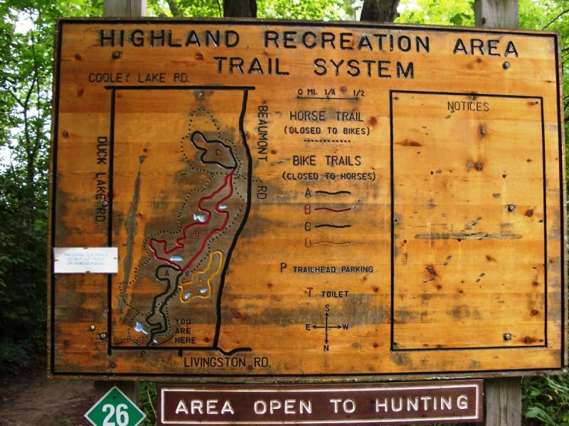 Map of the Highland Recreation Area trail system, displaying designated horse and bike trails, parking location, and orientation markers, with a note indicating the area is open to hunting. Highland Recreation mountain bike trail.