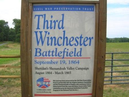 Sign at the Third Winchester Battlefield, featuring the title, date of the battle (September 19, 1864), and information about Sheridan's Shenandoah Valley Campaign, along with contact details for the Civil War Preservation Trust. The background includes a grassy field and trees. 3rd Battle Of Winchester Trail mountain bike trail.