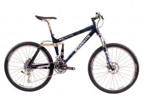 A blue and black mountain bike with a modern design, featuring front suspension, disc brakes, and a gear system. The bike is positioned against a white background, highlighting its sleek frame and components.