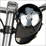 Close-up image of a small fan mounted on a bike handlebar, featuring a black casing and a four-blade propeller, designed to provide cooling airflow while riding.