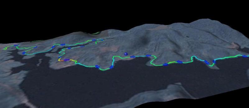 3D topographical map showing a mountainous landscape with a winding trail marked by a green line and blue points along the path. The background is dark, emphasizing the terrain features of the area. Moraine State Park mountain bike trail.