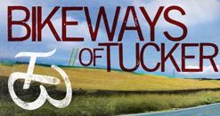 Graphic featuring the text "Bikeways of Tucker" with a bicycle symbol, set against a backdrop of fields and a blue sky.