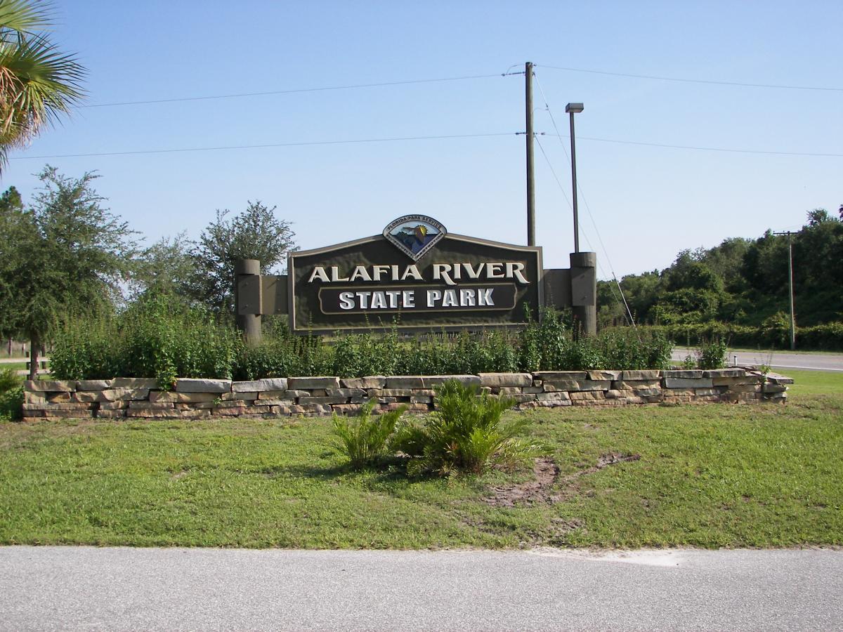 Sign marking the entrance to Alafia River State Park, surrounded by greenery and natural landscaping on a sunny day. Alafia River State Park mountain bike trail.