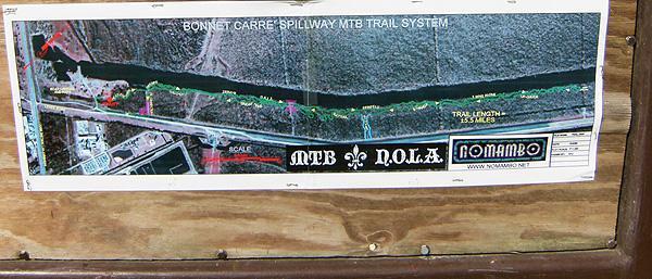 A map of the Bonnet Carré Spillway MTB Trail System, showing various trails along a riverbank. The map includes color-coded trail segments, markers for trail lengths in miles, and branding for MTB N.O.L.A and Nomambo. Bonnet Carre Spillway Trail mountain bike trail.