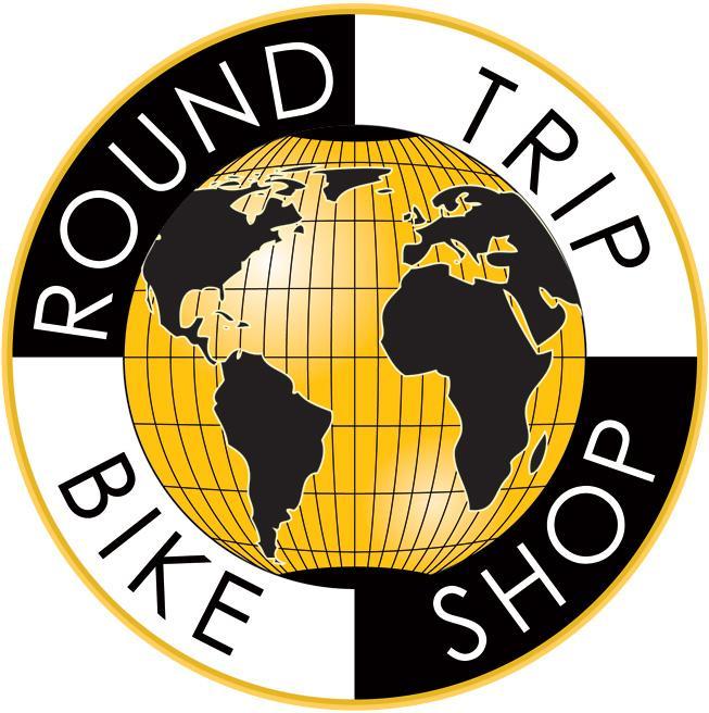Logo of Round Trip Bike Shop featuring a stylized globe with a grid pattern, surrounded by the text "ROUND TRIP" at the top and "BIKE SHOP" at the bottom, all within a circular design in black, white, and gold colors.