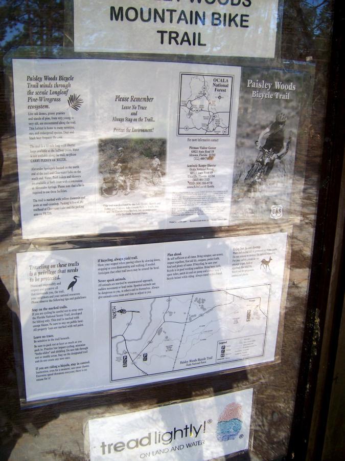 Signage for the Paisley Woods Mountain Bike Trail, featuring information on trail guidelines, a map of the trail system, and reminders for environmental protection. The signs emphasize safe biking practices, respect for nature, and provide contact information for further inquiries. Paisley Woods Trail mountain bike trail.