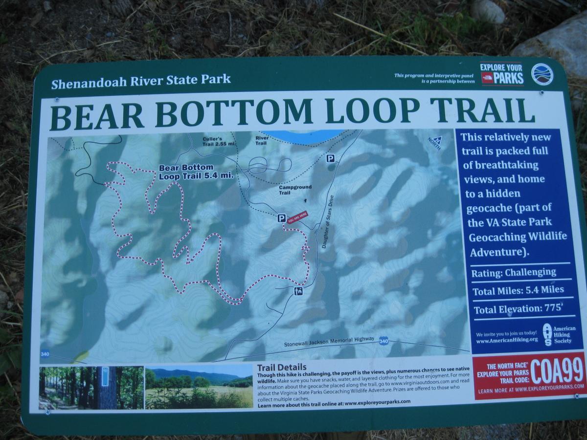 Map of the Bear Bottom Loop Trail at Shenandoah River State Park, detailing a 5.4-mile hiking route with a challenging rating. The map includes information about the trail, highlights geocaching opportunities, and features notes on total elevation. Various landmarks and paths are marked, providing guidance for hikers exploring the area. Bear Bottom Loop mountain bike trail.