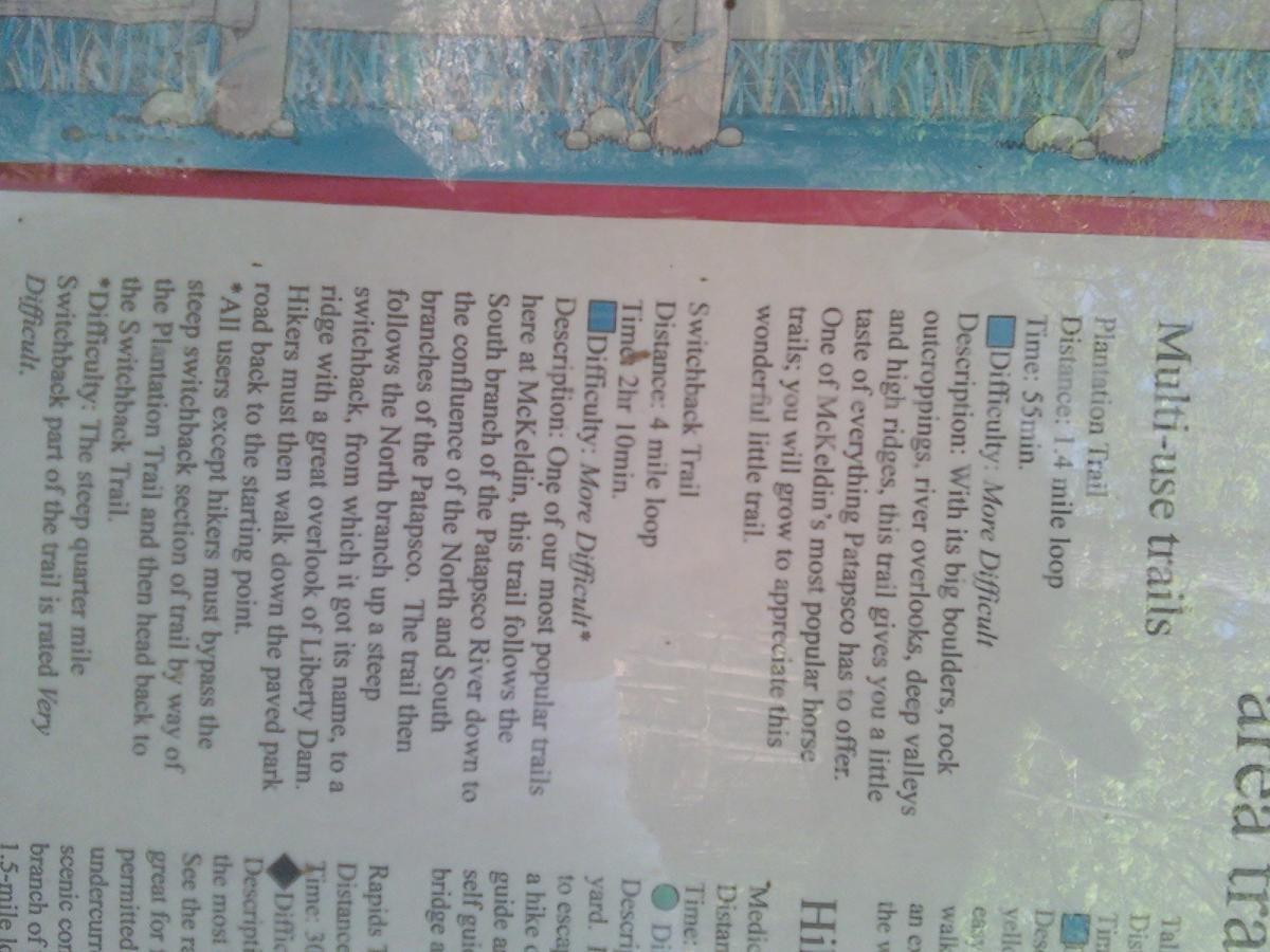 Information sign detailing multi-use trails at a recreational area, including descriptions of the Plantation Trail and Switchback Trail, along with their respective distances, difficulty levels, and hiking instructions. The sign includes a map and other related information for outdoor enthusiasts. Patapsco Valley State Park (mckeldin Area) mountain bike trail.