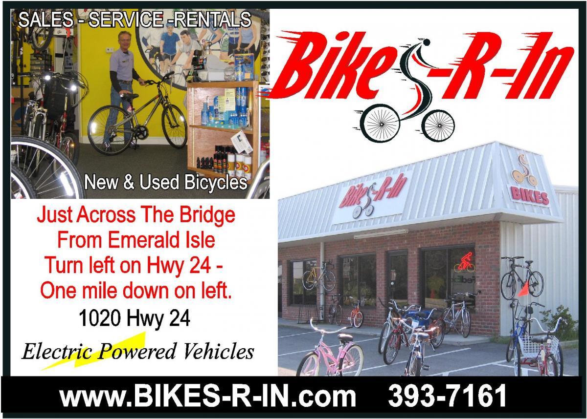 An image featuring a bicycle shop named "Bikes-R-In," showcasing new and used bicycles for sale, including electric powered vehicles. Inside, a store employee stands beside a bike against a vibrant yellow wall. The exterior displays a variety of bicycles, with the shop