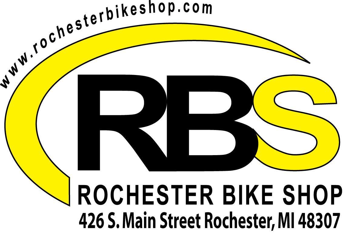 Logo of Rochester Bike Shop featuring the acronym "RBS" prominently displayed. Below, the full name "ROCHESTER BIKE SHOP" is written, along with the address "426 S. Main Street Rochester, MI 48307" and the website "www.rochesterbikeshop.com" in a circular design. The logo has a yellow and black color scheme.