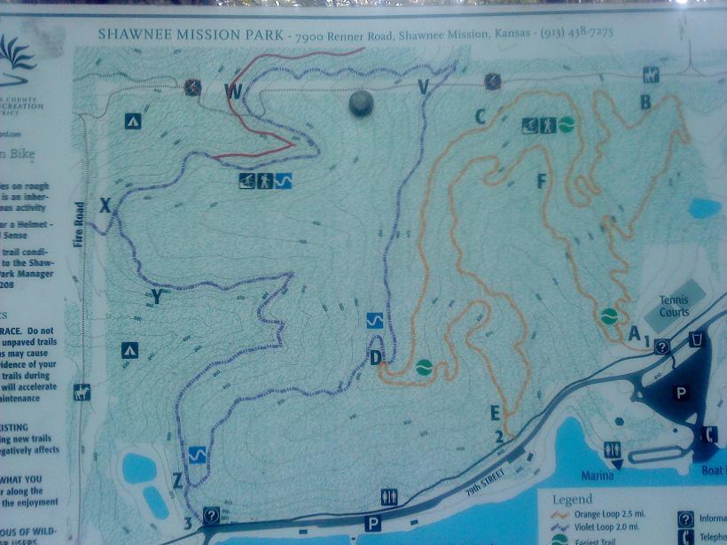 Map of Shawnee Mission Park showing trails and amenities such as picnic areas, restrooms, and parking. The map includes various trail routes marked in different colors, with an accompanying legend for orientation. Key features like tennis courts and a marina are also indicated. Shawnee Mission Park mountain bike trail.