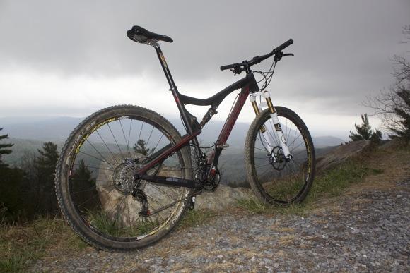 A mountain bike parked on a rocky trail overlooking a scenic landscape under a cloudy sky. Pinhoti Trail: P1 / Bear Creek Pinhoti mountain bike trail.