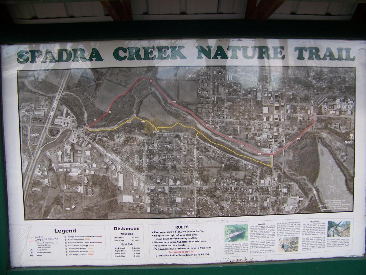 Map of the Spadra Creek Nature Trail, displaying the trail's route marked in red and yellow, along with a legend indicating distances and trail rules. The map features an aerial view of the surrounding area, including nearby streets and landmarks. Spadra Creek Nature Trail mountain bike trail.