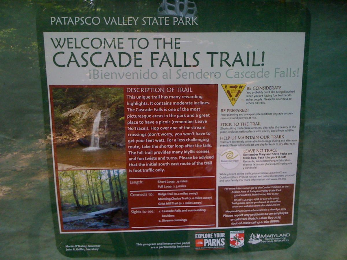 Welcome sign for the Cascade Falls Trail at Patapsco Valley State Park. The sign includes a description of the trail, its highlights, length, and connecting trails. It emphasizes the importance of respecting nature and adhering to safety guidelines, with tips on being considerate of other visitors and maintaining the trails. The sign features images of Cascade Falls and surrounding nature, along with contact information for the park. Patapsco Valley State Park (Avalon Area) mountain bike trail.
