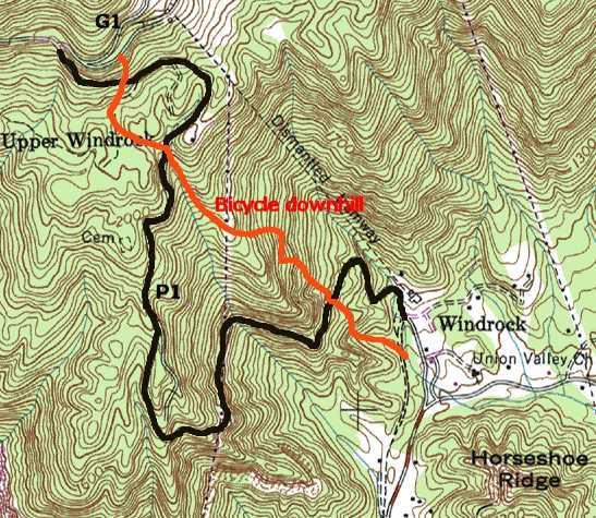 A topographic map showing a bicycle downhill route marked in red. The route begins at "Upper Windrock" and winds down towards the area labeled "Windrock," with contour lines indicating elevation changes in the landscape. The geographical features, including nearby names like "Horseshoe Ridge," are also visible. Windrock Bike Park mountain bike trail.