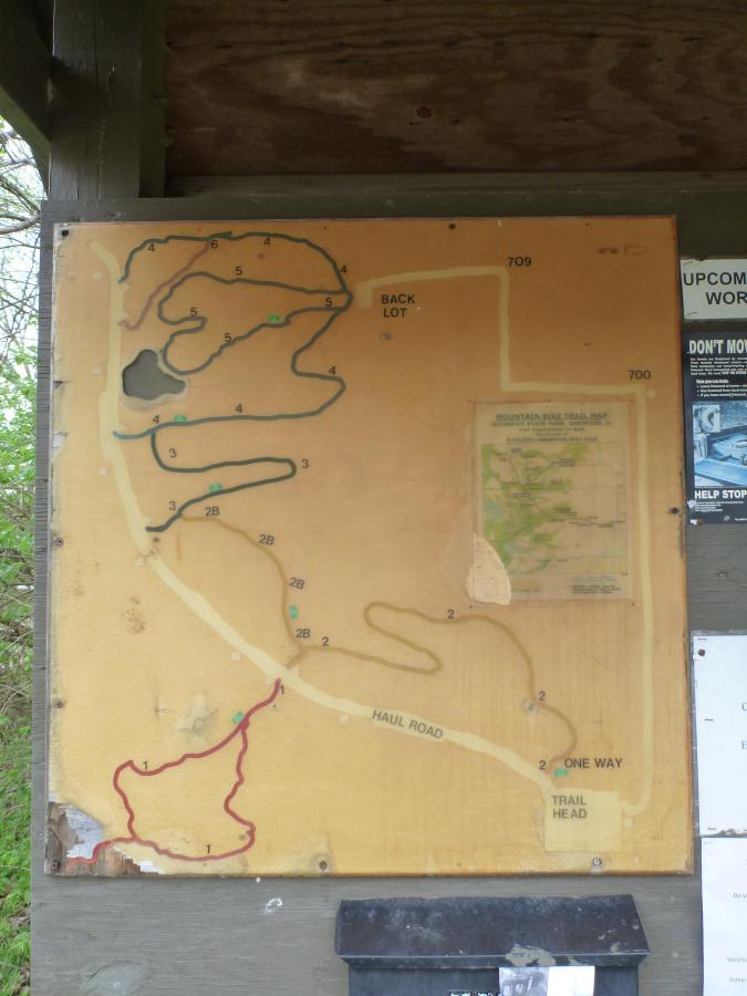 Map of mountain bike trails displaying various routes and markers, including "Back Lot," "Haul Road," and a "Trail Head." The map features colored trails indicating different paths, numbered sections, and nearby information signs. Kickapoo mountain bike trail.
