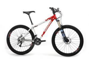 Banshee Viento: Mountain bike with a white and red frame, featuring thick tires, front suspension, and disc brakes, positioned on a plain background.