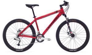 Cannondale F5: Red mountain bike with a sturdy frame, front suspension, and knobby tires, positioned against a plain background.