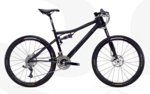 A black mountain bike with a sleek frame, front suspension, and disc brakes, positioned against a light background.