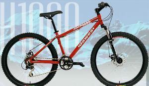 Dawes Cycles USA Haymaker 1000: A red mountain bike displayed with a snowy mountain backdrop, featuring thick tires and a sturdy frame. The bike is labeled "H1000" prominently on its side.
