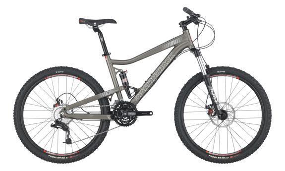Diamondback Sortie 1: A gray mountain bike with wide tires and disc brakes, featuring a dual suspension system and a sleek frame design. The handlebars are equipped with standard grips and gear shifters.