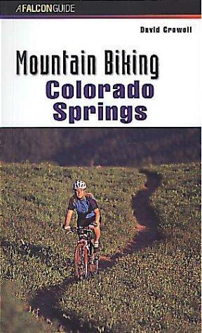 Falcon Guides Mountain Biking Colorado Springs: Image of a book cover titled "Mountain Biking Colorado Springs" by David Crawell. The cover features a person riding a mountain bike on a winding trail surrounded by greenery and hills. The title is prominently displayed at the top in large, bold letters.