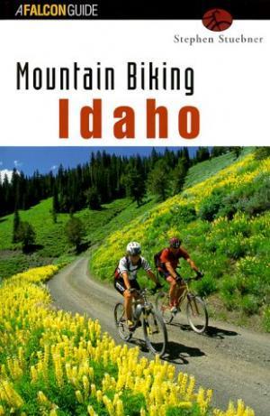 Falcon Guides Mountain Biking Idaho: Alt text: Book cover for "Mountain Biking Idaho" by Stephen Stuebner featuring two mountain bikers navigating a trail surrounded by lush greenery and vibrant yellow wildflowers.