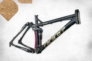 Felt Virtue: A black and gold mountain bike frame shown on a textured background. The frame features a rear suspension system and is positioned at an angle to showcase its design.