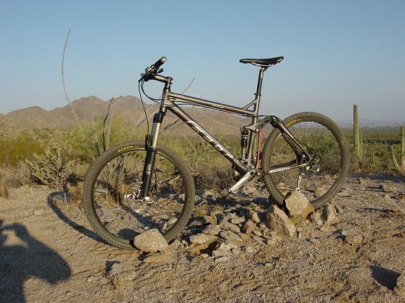 Felt Virtue Two: A mountain bike is parked on a rocky surface in a desert landscape, with mountains visible in the background under a clear blue sky.