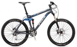 Fuji Reveal 1.0: A mountain bike with a sleek gray frame, blue accents, and advanced suspension features. It has thick, knobby tires suitable for off-road terrain and a modern design with a lightweight build.
