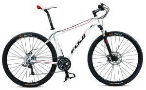 Fuji Tahoe 29 SL: A white and black mountain bike with wide tires, a disc brake system, and a sleek frame design, featuring a red and black seat. The bike is positioned to showcase its side profile.