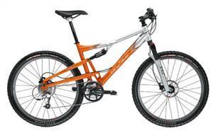 Gary Fisher Caliber: A mountain bike with a silver and orange frame, featuring thick tires, front suspension, and a dual suspension system, positioned on a white background.