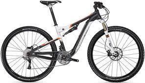 Gary Fisher HiFi Deluxe: A modern mountain bike with a black and white frame, featuring orange accents, front suspension, and disc brakes. The bike is positioned against a plain background.