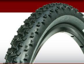 Geax Barro Mountain: Image of a black mountain bike tire with pronounced treads, positioned against a red and white background. The tire showcases its robust design, emphasizing traction for off-road conditions.