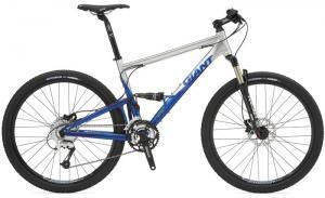 Giant Anthem 2: A side view of a mountain bike featuring a blue and silver frame, with black tires and a front suspension fork. The bike has disc brakes and multiple gears, indicating it's designed for off-road biking. The brand name "Giant" is visible on the frame.