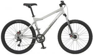 Giant Ranier: A silver mountain bike with thick tires, a sturdy frame, and adjustable seat height. The bike features front suspension and multiple gears, designed for off-road riding.