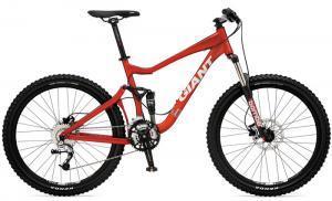 Giant Reign 2: Mountain bike with a bright red frame, front suspension, and disc brakes, featuring knobby tires for off-road performance. The bike is designed for trail riding and has a sleek, modern design.