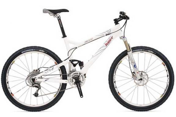 Giant Trance 1: A white mountain bike with a sleek design, featuring a dual suspension system, wide tires, and disc brakes. The bike has a lightweight frame and is equipped with a gear system, making it suitable for off-road trails and rugged terrain.