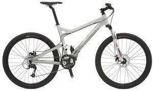 Giant Trance: A silver mountain bike with a dual suspension frame, equipped with disc brakes and thick tires, shown from the side.