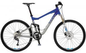 Giant Trance X3: Mountain bike featuring a blue and silver frame with front suspension, wide tires, and a prominent gear system. The bike is designed for off-road cycling and has a sturdy build for durability and performance.