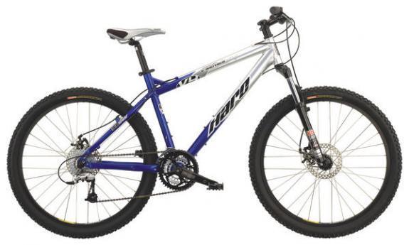 Haro V4: A blue and silver mountain bike with wide tires, disc brakes, and a lightweight frame. It features a front suspension fork and multiple gears, designed for off-road trails and rugged terrain. The bike is positioned on a plain background.