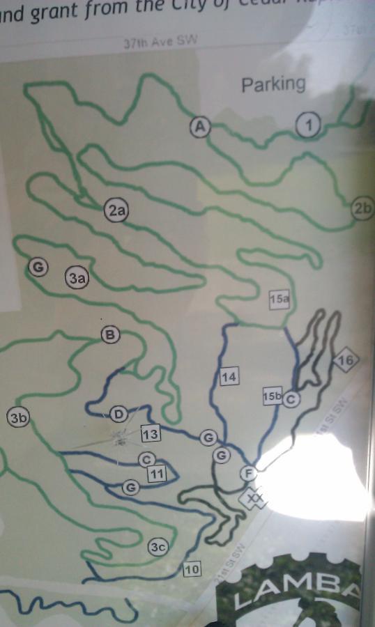 Alt text: "Map of a biking trail system at Cedar Rapids, showing various trails labeled with letters and numbers, along with a designated parking area." Beverly Park mountain bike trail.